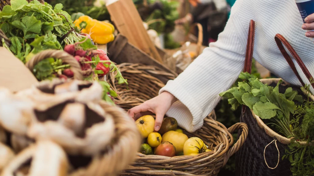 iagen de una persona comprando alimentos frescos en un mercado local